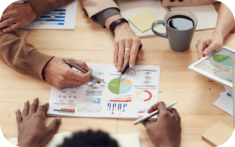 Group of Hands Pointing to Data on Page